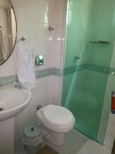 ein Badezimmer mit Dusche, Toilette und Waschbecken in der Unterkunft Meu verao em ITAPEMA in Itapema