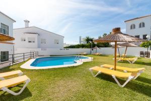 podwórko z basenem, krzesłami i parasolem w obiekcie Luna de Nerja w mieście Nerja
