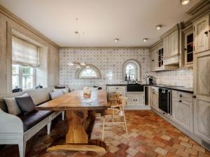 a kitchen with a wooden table and a couch at SalzWasserHerz Senhoog Luxury Holiday Homes ***** in Morsum