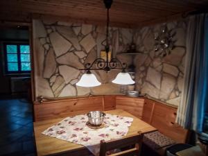 a dining room with a table and a stone wall at Lütt Stuuv am Dorfanger in Barth