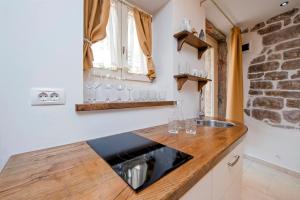 uma cozinha com um lavatório e um balcão com copos em Studio S. Benedetto em Rovinj