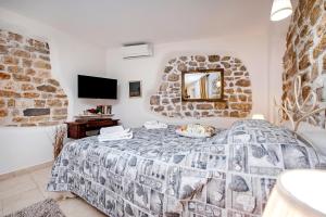 um quarto com uma cama e uma parede de pedra em Studio S. Benedetto em Rovinj