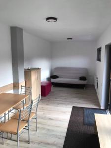 Una sala de estar con un sofá, mesas y sillas. en Orion Apartments (family), en Lunca de Sus
