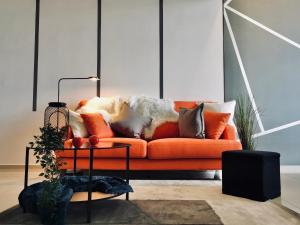 an orange couch with pillows on it in a living room at Ekocheras Suite in Kuala Lumpur