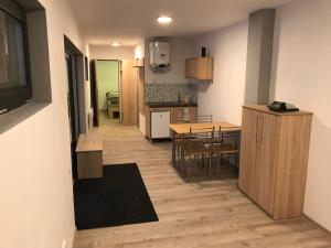 een keuken en eetkamer met een tafel en stoelen bij Orion Apartments (family) in Lunca de Sus