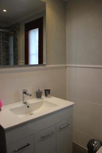 ein Badezimmer mit einem weißen Waschbecken und einem Spiegel in der Unterkunft 152 Tropicana Park - Deniasol in Denia