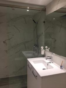 a bathroom with a white sink and a mirror at Cosy Appartment in Rabat