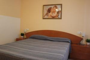 une chambre avec un lit avec un tableau sur le mur dans l'établissement 187 Palm Beach - Deniasol, à Dénia 11 autres photos
