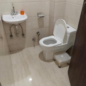 a bathroom with a toilet and a sink at Sprinklers in New Delhi