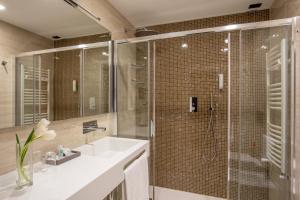 baño con lavabo y ducha con puerta de cristal en Hotel Alexandra, en Roma