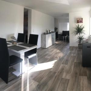 a living room with wood floors and a table and chairs at Casa Ledara Baumberge in Billerbeck