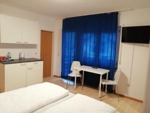 Schlafzimmer mit einem Bett, einem Tisch und Stühlen in der Unterkunft Pension Blaues Haus in St. Blasien