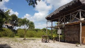 un edificio con tetto di paglia e tavolo di Mida Creek Nature Camp a Watamu