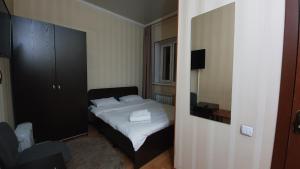 a small bedroom with a bed and a mirror at Fiveseasons in Almaty