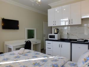a kitchen with white cabinets and a table and a microwave at Old City Pansiyon in Istanbul