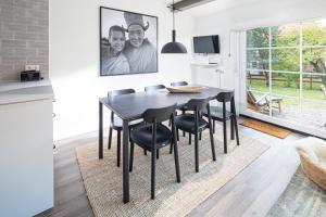 a kitchen and dining room with a black table and chairs at Les Trois Voiliers - mit Sauna in Juist