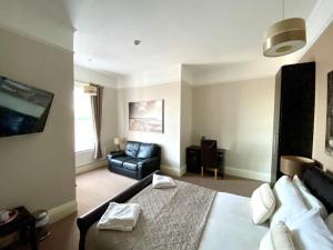 a bedroom with a bed and a couch in it at Somerton Lodge in Shanklin