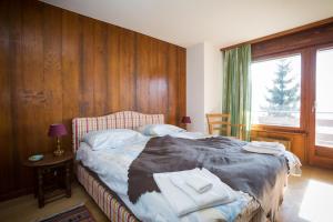 ein Schlafzimmer mit einem Bett mit einer Holzwand in der Unterkunft Apartment Royal 6 in Verbier