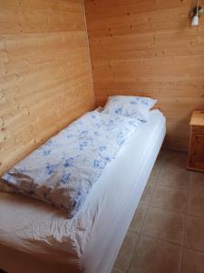 a bed in a room with a wooden floor at Guesthouse Stöng and Cottages in Stöng