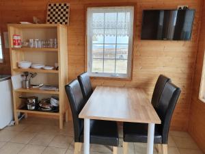a kitchen with a table and chairs and a window at Guesthouse Stöng and Cottages in Stöng