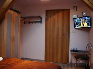 a bedroom with a door and a television on the wall at Pentagos Centrum in Poznań