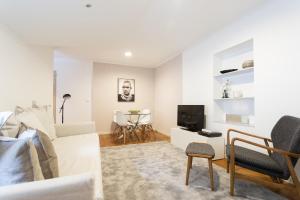 sala de estar blanca con sofá y TV en Living Bairro Alto V en Lisboa