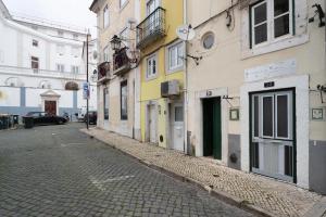 a cobblestone street in an alley with buildings at Living Bairro Alto V in Lisbon