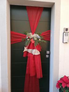 a red rose in a red dress next to a red door at La Villa 31 - Rosignano Marittimo - in Rosignano Marittimo