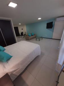 a bedroom with a large white bed and a couch at Miralejos 7 Turquesa in Villa Carlos Paz