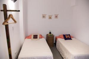 two beds in a room with white walls at Hostel Cha in Resistencia