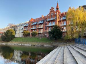 budynek obok rzeki przed budynkiem w obiekcie Prestige Apartments 12 we Wrocławiu