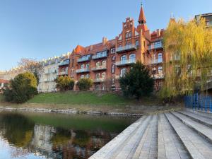 a building next to a river in front of a building at Prestige Apartments 12 in Wrocław