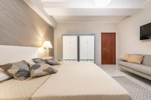 una grande camera da letto con un grande letto e un divano di Suite Home Simius a Villasimius