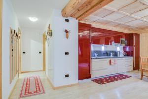 Una cocina grande con gabinetes blancos y techo de madera. en Cesa San Florian - Appartamento 1, en Canazei 19 fotos más