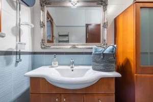 un bagno con lavandino e specchio di Suite Home Simius a Villasimius Altre 21 foto