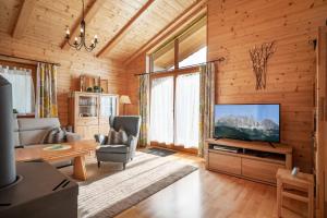 a living room with a flat screen tv in a wooden wall at Chalet Terry in Sankt Johann in Tirol