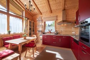 a kitchen with red cabinets and a wooden ceiling at Chalet Terry in Sankt Johann in Tirol