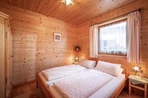 a bedroom with a bed in a wooden room at Chalet Terry in Sankt Johann in Tirol