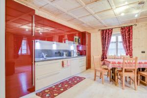 Una cocina y un comedor con mesa y sillas. en Cesa San Florian - Appartamento 1, en Canazei