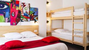 two bunk beds with red pillows in a room at hotel le beauséjour in Langogne