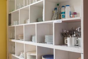 a white shelf with plates and utensils at Durness Youth Hostel in Durness