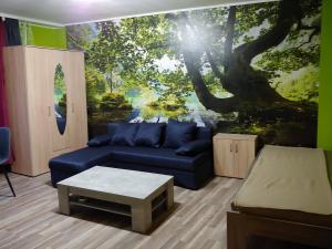 Una sala de estar con un sofá azul y un mural de árboles. en Duisburg Beeck, en Duisburg