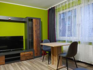 comedor con mesa, TV y paredes verdes en Duisburg Beeck, en Duisburg