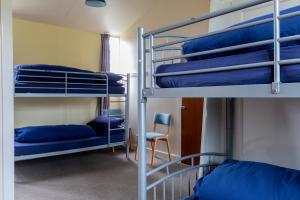 a room with two bunk beds and a chair at Durness Youth Hostel in Durness