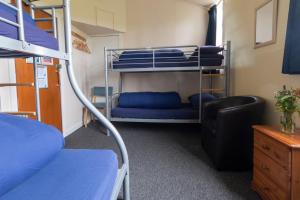 a dorm room with bunk beds and a chair at Durness Youth Hostel in Durness