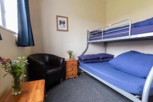 a bedroom with a bunk bed and a chair and a desk at Durness Youth Hostel in Durness