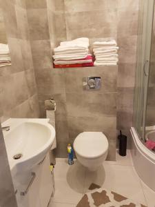 a bathroom with a toilet and a sink and towels at Apartament u Ewy w Kołobrzegu - Podczele in Kołobrzeg