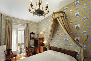 a bedroom with a bed and a chandelier at Hôtel de l'Abeille in Orléans