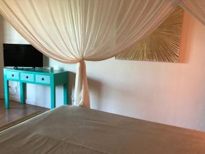 a bedroom with a bed and a table with a curtain at La Villa FLau Studio Azur in Sainte-Luce