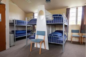 a room with bunk beds and a chair and a ladder at Durness Youth Hostel in Durness